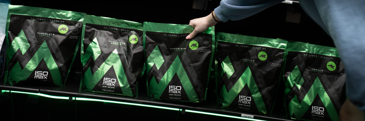 Person reaching for a package of ISO Max supplements on a shelf.
