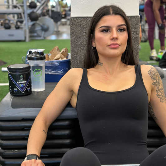 Woman sitting outdoors with a supplement container and water bottle on a table