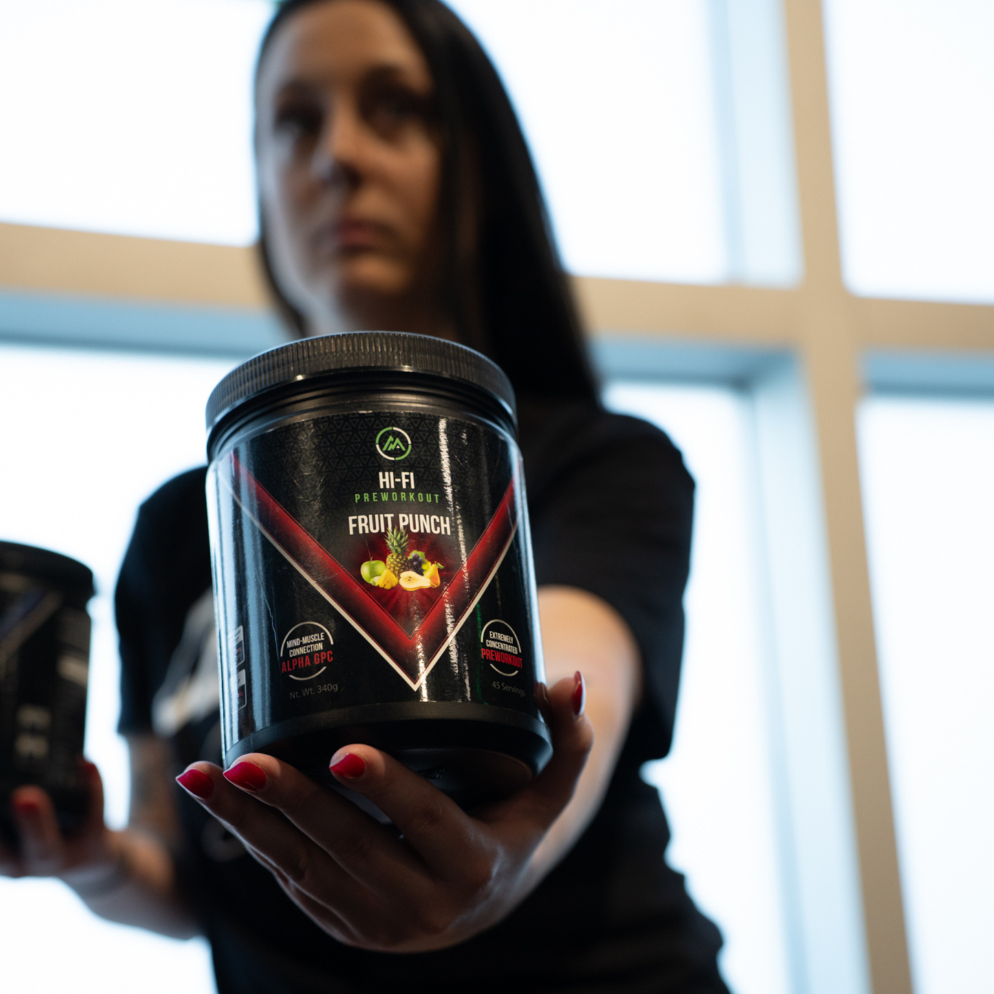 Person holding a container labeled 'Fruit Punch' in front of a blurred window.